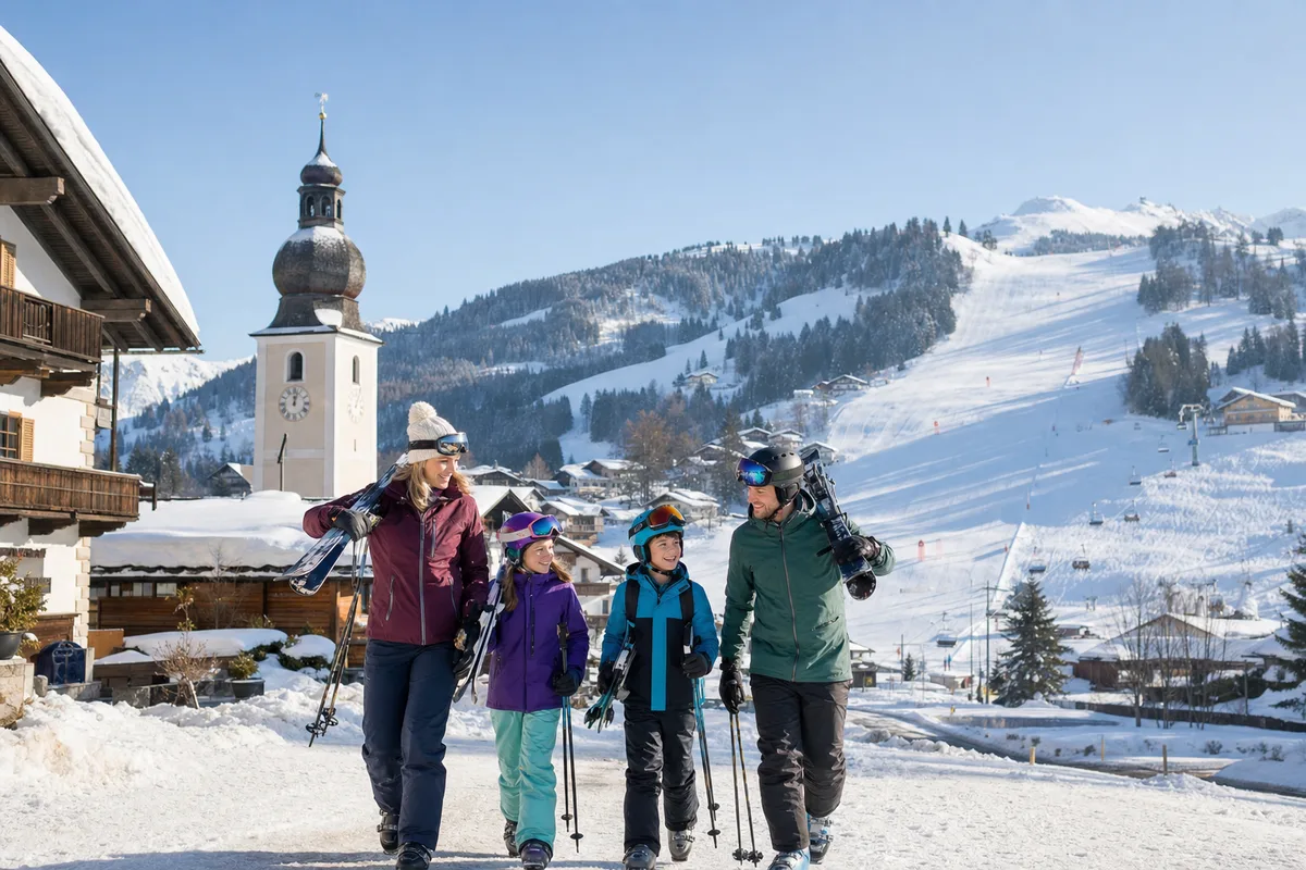 Gezin op weg naar de piste in een Oostenrijks bergdorp